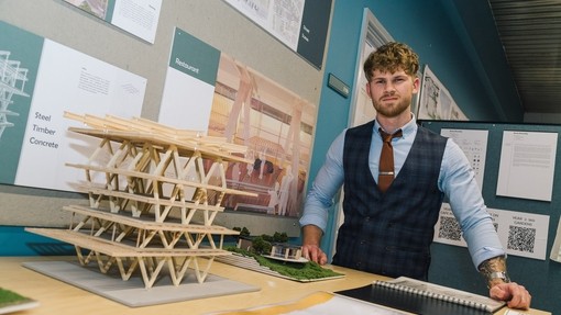 Drew Dennehy with his exhibition of architectural designs