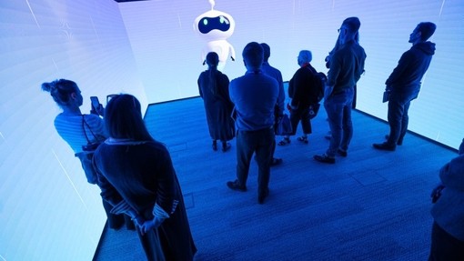 A group standing inside the brightly illuminated immersive room in Swansea.