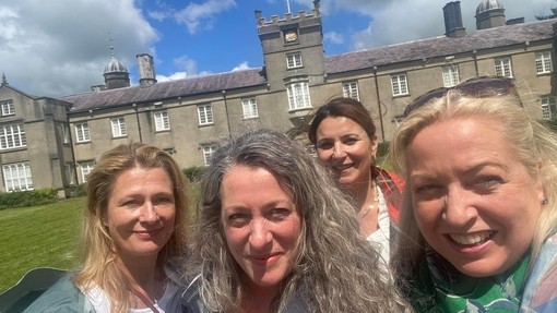 a group of people smiling at camera in front of Lampeter Old Building