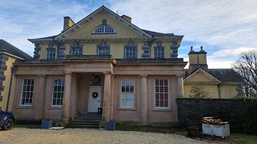 A stone fronted building with a wide sweeping gravel driveway in front.