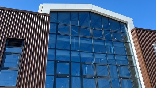 The glass fronted building with a brilliant blue sky behind.