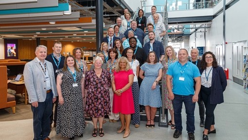 A large group of lecturers and students standing on the staircase in IQ.