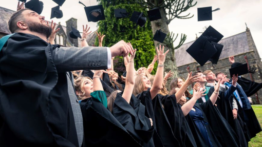 A group of happy graduates throwing their caps into the air in celebration.