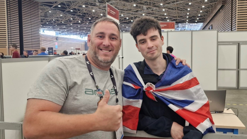 Two men, one draped in a British flag celebrate.