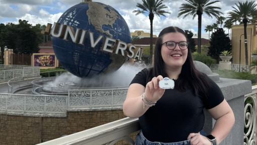 A happy smiling student standing in front of the Universal globe at Orlando.
