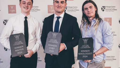 Three happy smiling contestants holding their grey slate winning trophies