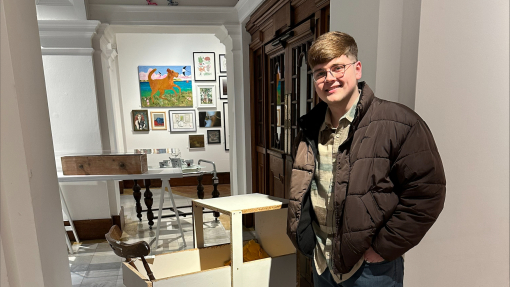 Luke Cotter standing with a piece of hi work at Swansea College of Art
