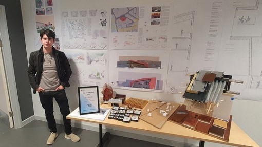 Jacob Davies Hannen, an architecture student at UWTSD, standing in front of his designs