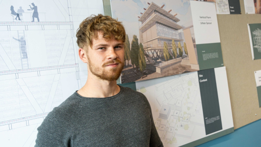 Student standing in front of drawing of urban vertical farm