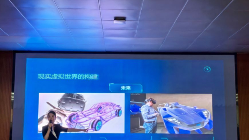 A woman holding a microphone standing in front of blue presentation slides.