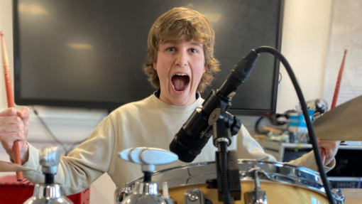 A student playing electronic drums.