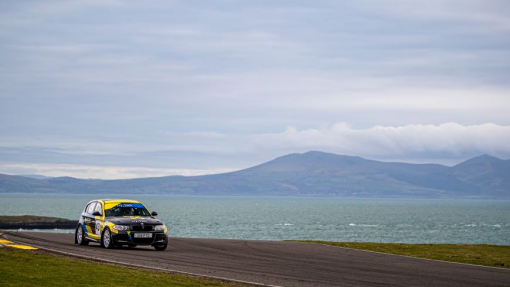 A rally car pictured outside against a blue sky background.