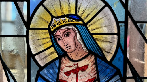 A beautiful stained glass window with blue, yellow and rose coloured glass.
