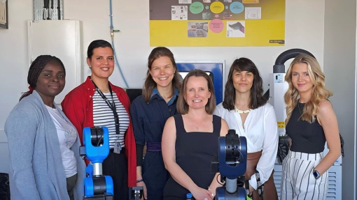 A group of smiling, happy people standing together in a room.