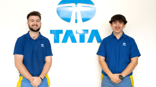 Two degree apprentices dressed in blue branded tops and jeans standing against a white background, with the blue and white Tata logo positioned between them.