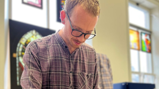 A student working with stained glass in a workshop.