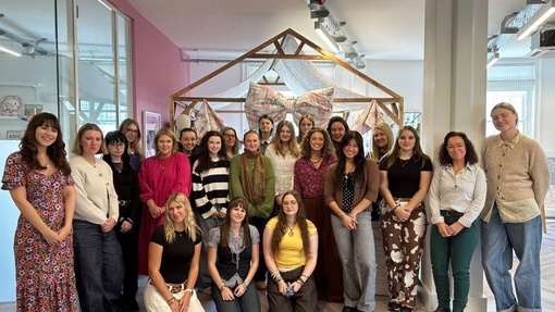 A group of students in a brightly coloured, vibrant, workshop.