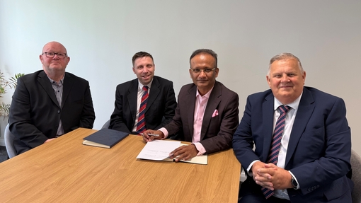 Representatives from UWTSD and Blue Ocean sitting at a table signing MOU