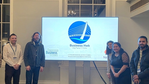 Five people stood next to large screen