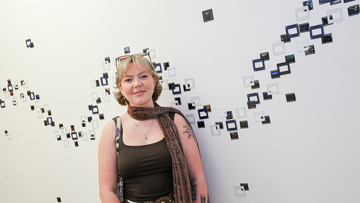 Exhibition Gallery student standing by work
