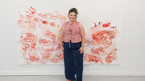 student in front of art work smiling