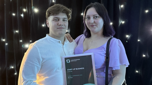 Ruslan and Lily at the awards ceremony holding the award 