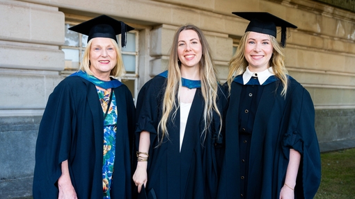 Three women dressed in caps and gowns 
