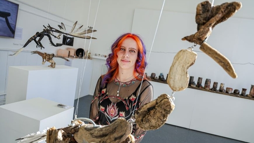 A student standing close to drift wood expressive forms.