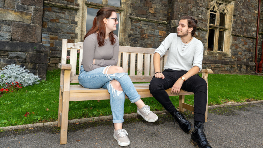 two students sitting on a bench