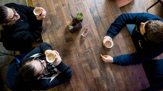 Three students enjoying a hot drink