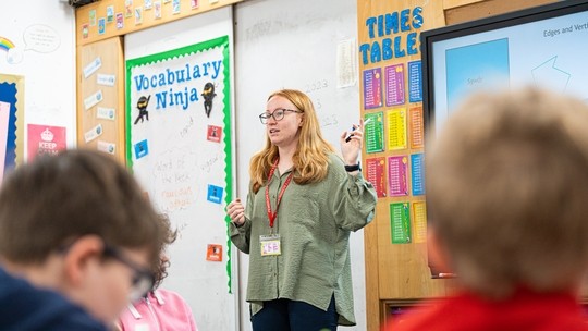 Image of teacher at the front of a class