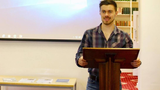 Image of Troy Wilkinson at a lectern 