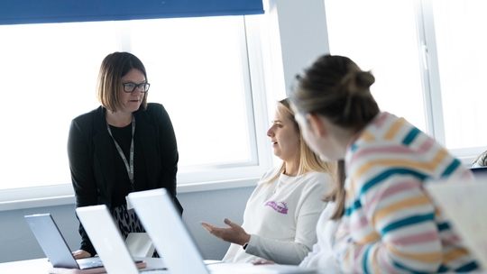 Images of lecturer talking to students in a classroom