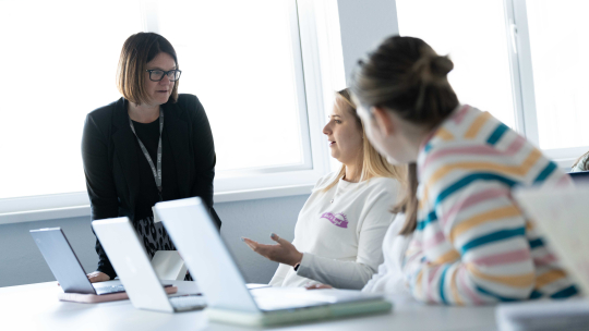 Images of lecturer talking to students in a classroom