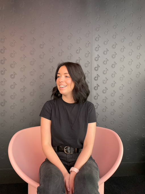 girl sitting smiling on a pink chair