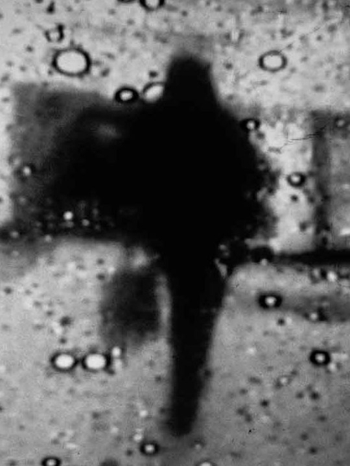 Black and white image of a dark silhouette with drops on the screen