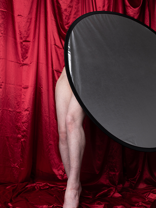 a pair of legs in front of a red draped curtain 