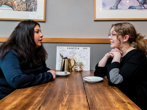 Two students in discussion at a coffee shop 