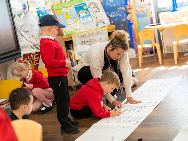 Primary teacher helping young student