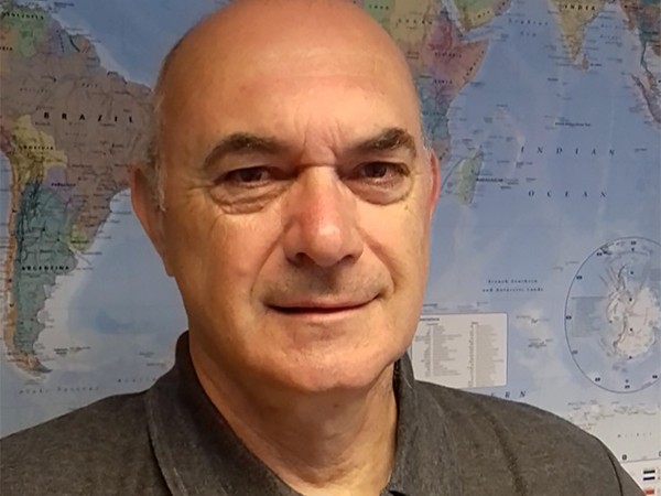 Andy Bevan in front of world map.