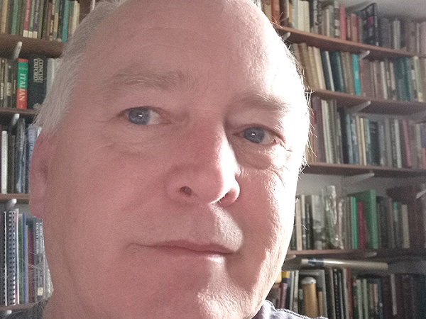 Martin Locock in a room lined with books.