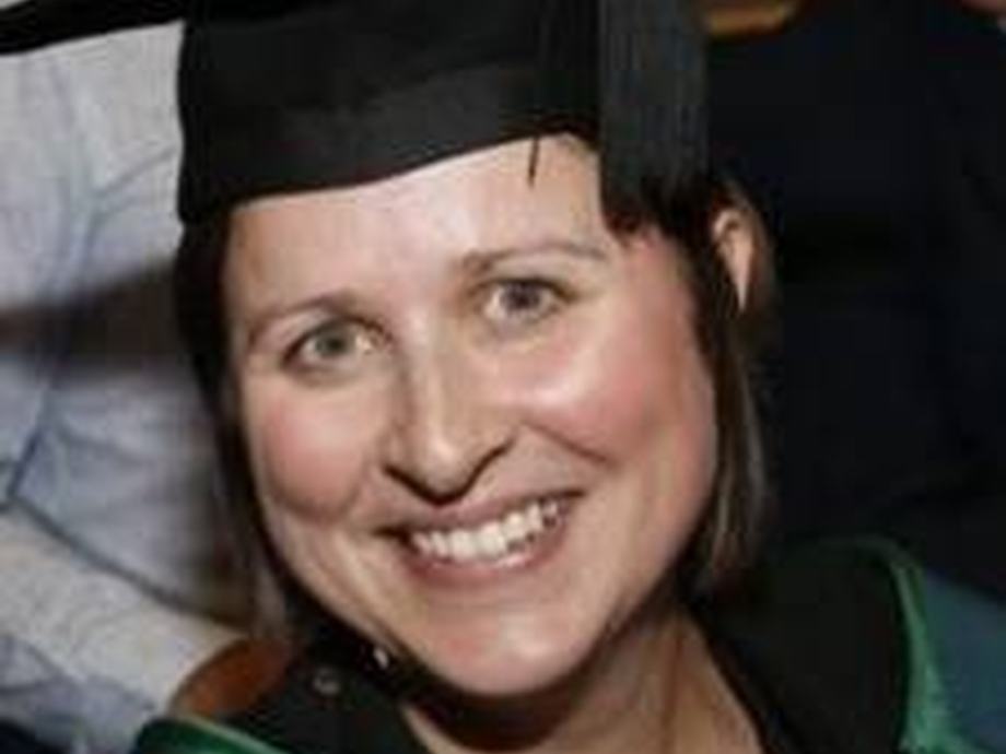 Senior Lecturer Angharad Lewis smiling in her cap and gown