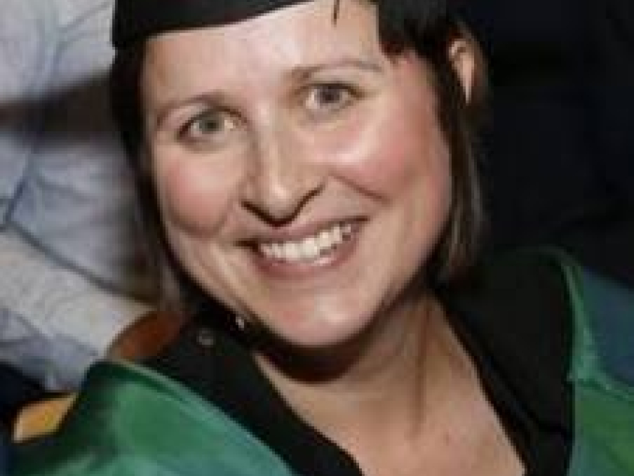 Senior Lecturer Angharad Lewis smiling in her cap and gown