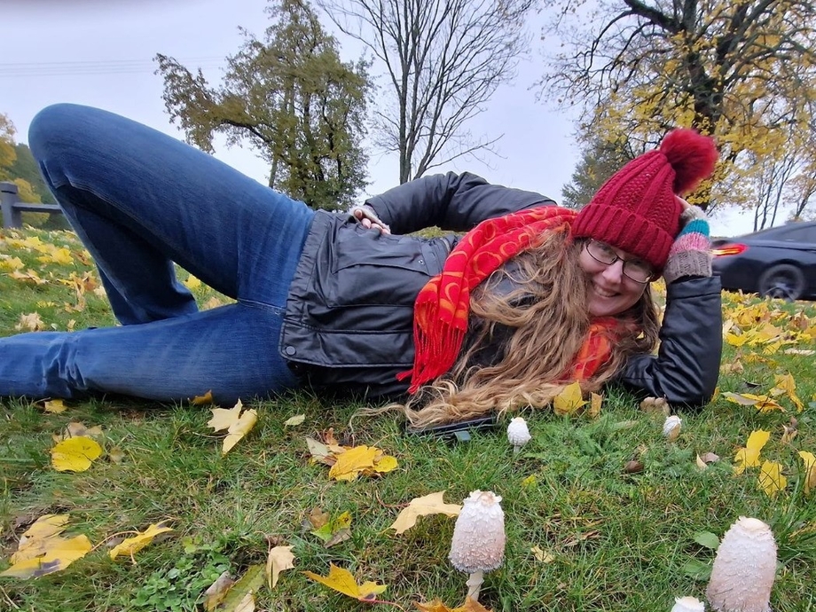 Elanor Alun lying in a field near mushrooms