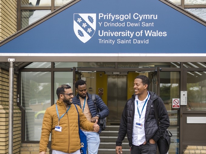 Three students walking out of UWTSD Cardiff