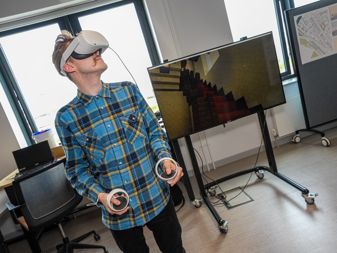 Myfyriwr yn defnyddio penset VR