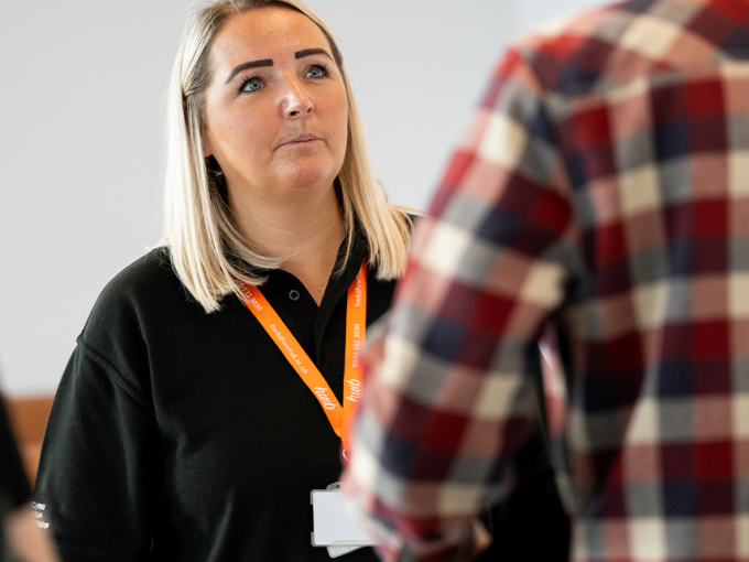 Aelod o staff yn helpu myfyriwr
