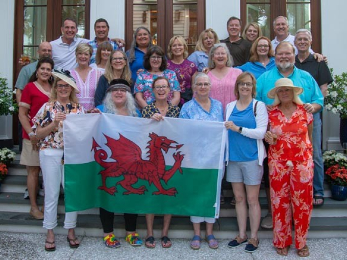 Criw o bobl yn sefyll gyda baner Cymru