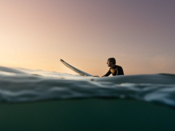 a man surfing in the sunset