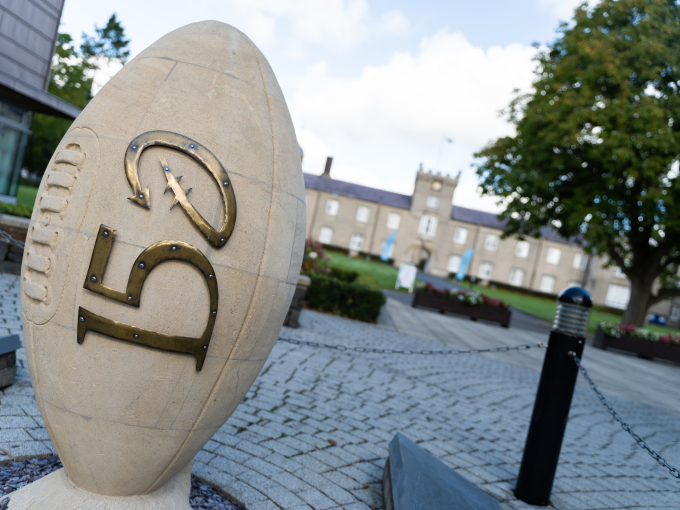 Image of Lampeter campus with rugby ball sculpture commemorating 150 years of the sport in Wales